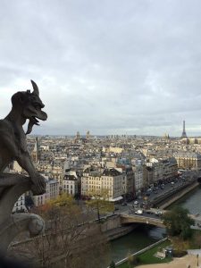 Picture of a gargoyle, the rooftops of Paris and the Eiffel Tower from the towers of Notre Dame Cathedral.