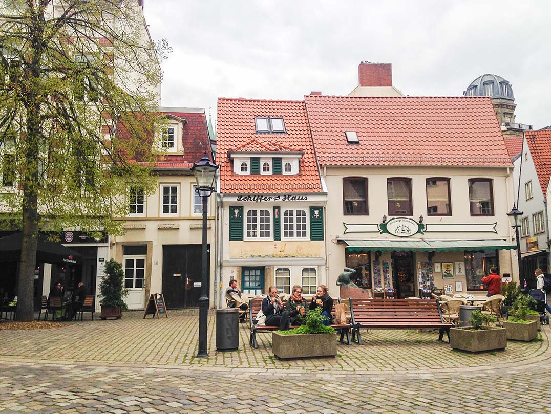 A plaza in Bremen, Germany with red roofed, colorful houses.