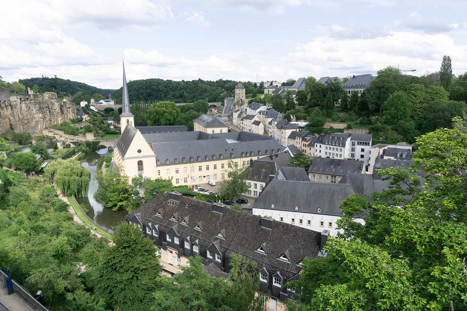 A view of the valley of Luxembourg and a church with a river running beside it.