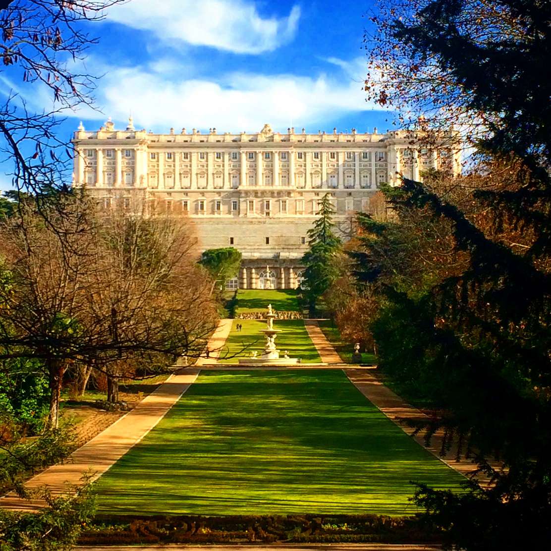 A picture of the royal palace of Madrid from Moro Park with a blue sky.