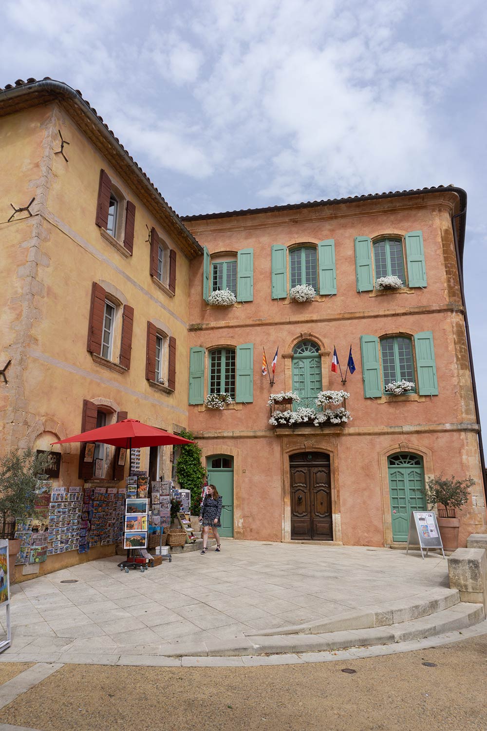 An orange colored building in a plaza in Rousellin, France.