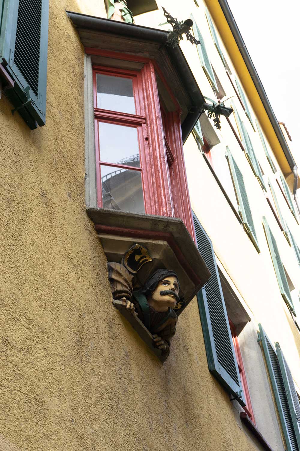 A carved face looks out at the streets from below a window in Konstanz, Germany.